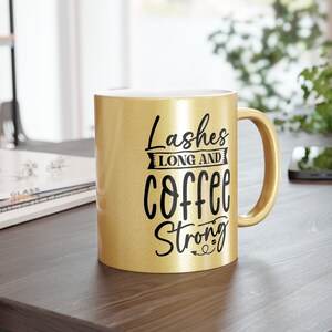 May include: A gold coffee mug with black lettering that reads "Lashes Long and Coffee Strong".