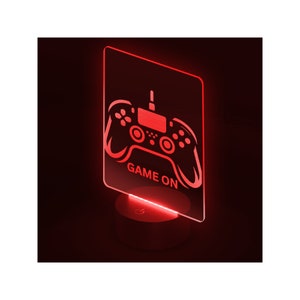 May include: Red LED night light with a game controller design and the text "GAME ON".