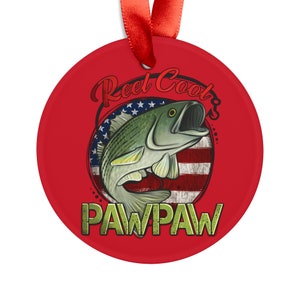 May include: Red round ornament with a green and white fish graphic, an American flag, and the text "Reel Cool Pawpaw".