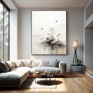 May include: A watercolor painting of a small island with trees and rocks in a misty lake. The painting is framed in a light wood frame and hangs on a white wall in a living room.