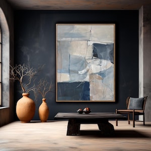 Puede incluir: Pintura abstracta con colores azules, grises y blancos en un estilo moderno. La pintura est&aacute; enmarcada y colgada en una pared azul oscuro en una habitaci&oacute;n con una mesa de caf&eacute; de madera y dos jarrones de terracota.