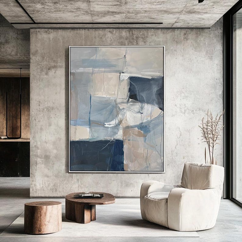 Puede incluir: Pintura abstracta de estilo moderno con tonos de azul, gris y beige. La pintura se muestra en una pared en un ambiente de sala de estar contempor&aacute;neo.
