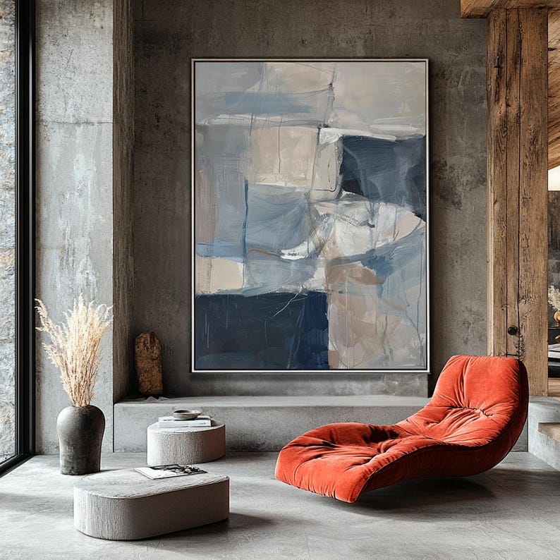 Puede incluir: Pintura abstracta con formas geom&eacute;tricas en tonos de azul, gris y beige. La pintura est&aacute; colgada en una pared gris en una sala de estar moderna con una chaise longue roja y mesas auxiliares de hormig&oacute;n.