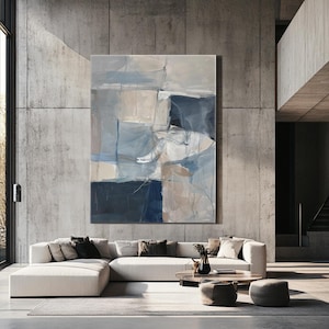 Puede incluir: Pintura abstracta con tonos de azul, blanco y beige. La pintura est&aacute; colgada en una pared de hormig&oacute;n en un sal&oacute;n moderno.