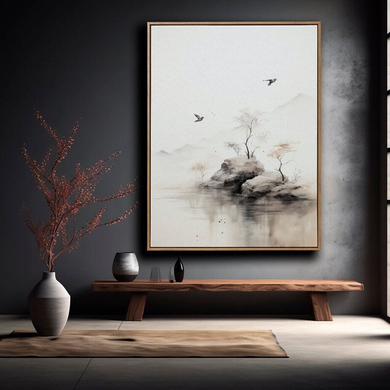 May include: A watercolor painting of a misty landscape with a small island, two trees, and two birds flying overhead. The painting is framed in a light wood frame and hangs on a dark gray wall.