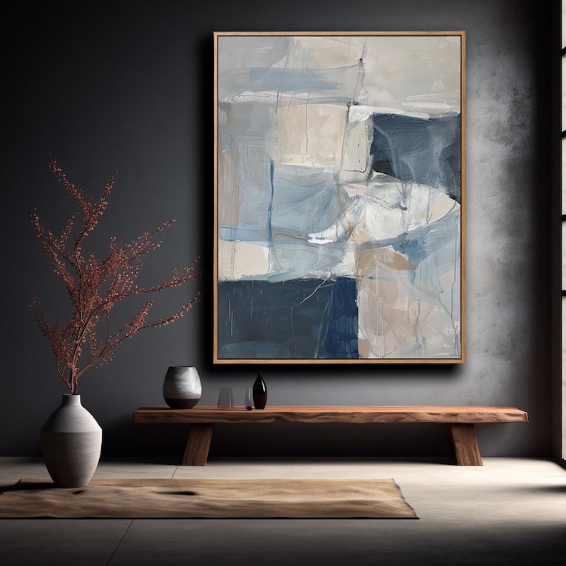 Puede incluir: Pintura abstracta de estilo minimalista con tonos de azul, gris y blanco. La pintura est&aacute; enmarcada en un marco de madera natural y se exhibe en una pared en un interior moderno.