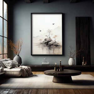May include: A black framed watercolor painting of a small island with trees and birds flying over a body of water. The painting is hanging on a gray wall in a modern living room with a couch, coffee table, and plants.