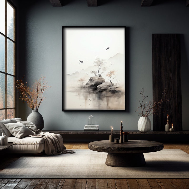 May include: A black framed watercolor painting of a small island with trees and birds flying over a body of water. The painting is hanging on a gray wall in a modern living room with a couch, coffee table, and plants.