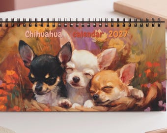 May include: A spiral-bound desk calendar titled Chihuahua calendar 2027, featuring an artistic illustration of three small dogs in black, white, and tan colors nestled together amidst a colorful, painterly floral background.