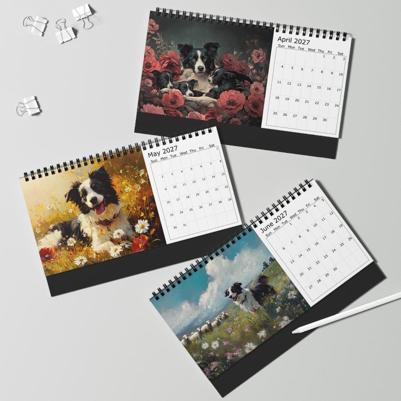 May include: Three spiral-bound desk calendars featuring illustrations of black and white border collie dogs. The pages display the months of April, May, and June 2027 with grid layouts. The imagery includes floral backgrounds and outdoor landscapes.