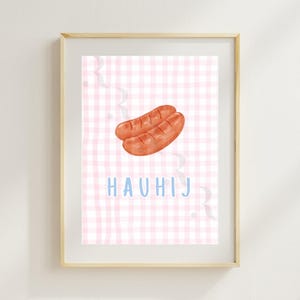 Può includere: Stampa incorniciata con due salsicce ad acquerello su sfondo rosa a quadretti. La parola "HAUHIJ" è scritta in azzurro. L'opera è racchiusa in una cornice di legno chiaro.