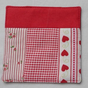 Peut inclure: Sous-verre en patchwork de tissu rouge, blanc et rose avec un motif vichy et une bordure de cœurs et de points.
