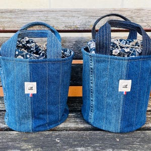 Bolso de mano con cordón ajustable, fabricado en tela vaquera reciclada y con base redonda.