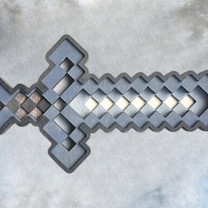 May include: A silver Minecraft sword with a pixelated design. The sword is made of metal and has a sharp point.