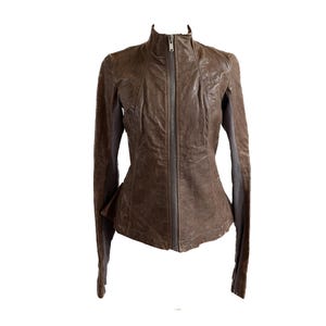 May include: A brown leather jacket with a zip fastening and a stand-up collar.