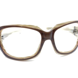 May include: Brown and beige plastic framed spectacles with a cat-eye shape.