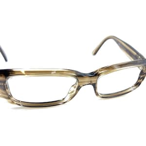 Puede incluir: Un par de gafas con montura marrón claro estampada y lentes transparentes. Las patillas son de color marrón oscuro. Las gafas están sobre un fondo blanco.