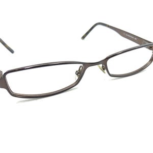 Op de afbeelding: Een bril van bruin metaal met een rechthoekig montuur.