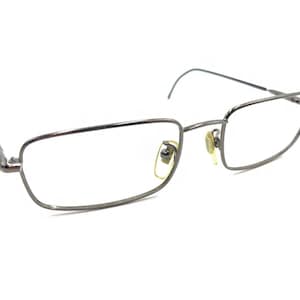 May include: Silver-toned metal eyeglasses with a rectangular frame and clear lenses.