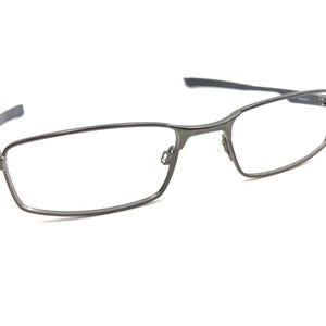 Puede incluir: Un par de gafas de metal plateado con montura rectangular.