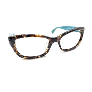 May include: Eyeglasses featuring a brown and black tortoiseshell pattern on the frames. The temples are a solid bright turquoise blue color. The lenses are clear and the frame shape is slightly rounded with a subtle cat-eye silhouette.