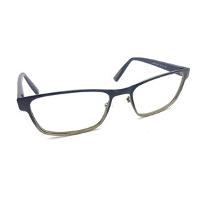 May include: Rectangular eyeglasses featuring a dark blue frame with a subtle metallic gold-toned lower rim. The glasses have thin temples and clear lenses, showcasing a clean, functional design with visible hinge hardware and nose pads.