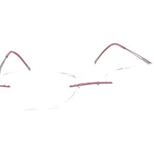 May include: Rimless eyeglasses with a burgundy accent on the temples and bridge. The lenses are clear and round. The frame is a minimalist design, suitable for everyday wear. The glasses are lightweight and appear to be made of metal.