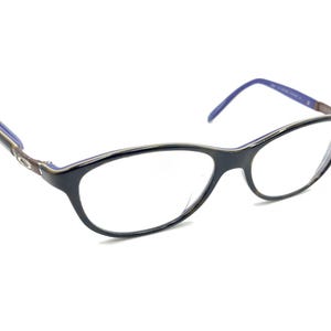Puede incluir: Gafas de pasta negras de estilo ojo de gato con detalles azules en las patillas.
