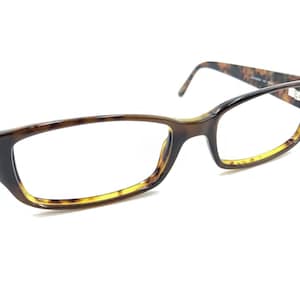 May include: Eyeglasses with a brown and tortoise shell pattern. The frames have a rectangular shape with a gradient of yellow at the bottom of the lenses. The temples have a tortoise shell pattern.