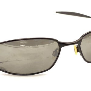 May include: Black metal frame sunglasses with gray lenses. The sunglasses have a thin metal frame and a simple design.