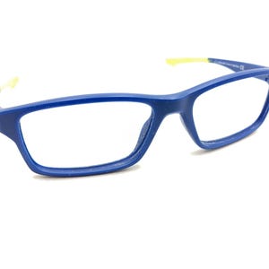May include: Blue rectangular eyeglasses with a yellow accent on the temple. The glasses have a modern design and are set against a white background. The frames are a solid, vibrant blue.