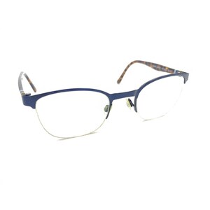 May include: A pair of eyeglasses featuring a dark blue semi-rimless frame with a thin metal bridge and clear lenses. The temples are patterned with a brown and black tortoiseshell design, and the nose pads are small and metallic in appearance.