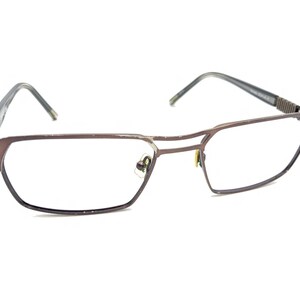 May include: Brown metal frame eyeglasses with clear lenses.