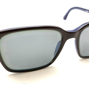 May include: Sunglasses featuring dark brown rectangular frames with a contrasting light blue interior lining. The lenses are a neutral grey tint, and the temples are thin, matching the blue interior color, providing a sleek and simple design.