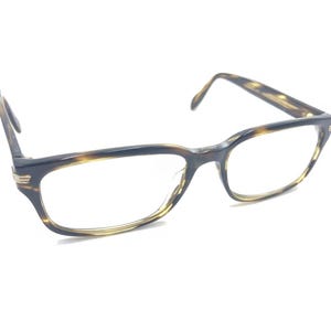 Puede incluir: Gafas de pasta de carey con montura rectangular y lentes transparentes.
