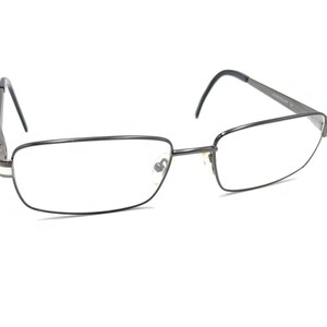 Puede incluir: Un par de gafas de metal plateado con montura rectangular.