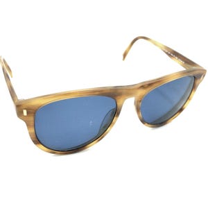 May include: Brown tortoiseshell sunglasses with blue lenses. The sunglasses have a classic, rounded shape.
