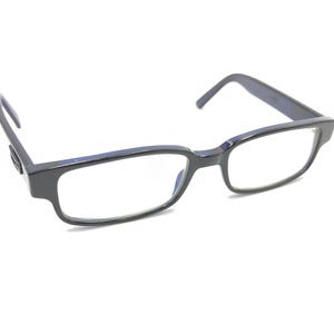 Puede incluir: Gafas rectangulares negras con lentes transparentes.