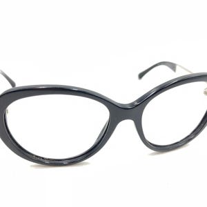 Op de afbeelding: Zwarte cat-eye bril met een zilveren accent op de pootjes.