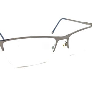 Puede incluir: Gafas de metal plateadas con montura rectangular y lentes transparentes.