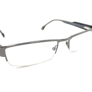 Puede incluir: Un par de gafas de media montura plateadas con lentes transparentes.