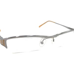 May include: Silver-toned eyeglasses with a clear lens and a row of small, clear rhinestones on the side of the frame.