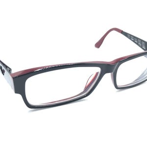 May include: Black and burgundy eyeglasses with a rectangular frame and clear lenses.