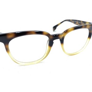 Può includere: Occhiali da vista in tartaruga con lenti trasparenti e un gradiente marrone e giallo.