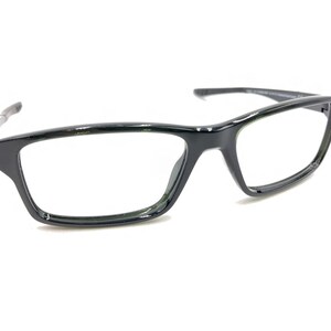 May include: Black rectangular eyeglasses with clear lenses. The frames are a glossy black with a subtle, modern design. The temples are thin and silver. The glasses are set against a white background.