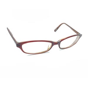 May include: A pair of eyeglasses featuring a dark reddish-brown frame with a glossy finish. The glasses have an oval-shaped lens design, thin temples, and a bridge connecting the two rims, presented against a plain white background.