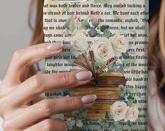 May include: A white iPhone case with a floral design and a book with the title "Little Women" on the cover. The case is made of a hard plastic material and has a clear back. The floral design is made up of white roses and green leaves. The book is open and the pages are visible. The case is designed to protect the phone from scratches and bumps.