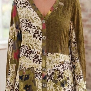 May include: A long-sleeve button-down cardigan featuring a patchwork design with olive green panels and cream-coloured sections adorned with dark brown floral patterns. The garment includes a V-neckline and a single patch pocket on the lower front.
