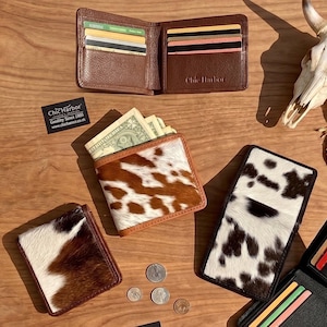 May include: A selection of leather wallets in different designs. Some are plain brown, while others have cowhide patterns in black and white or brown and white. Several wallets are open, showing credit cards and cash. The brand name "Chic Harbor" is visible.