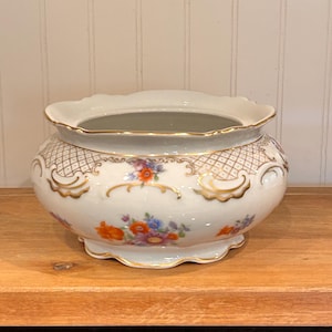 Könnte beinhalten: Set aus drei Keramikbechern mit gesprenkelter, matter Oberfläche. Die Becher sind in Creme-, Hellgrau- und Dunkelgrautönen gehalten. Jede Tasse hat ein schlichtes, minimalistisches Design.